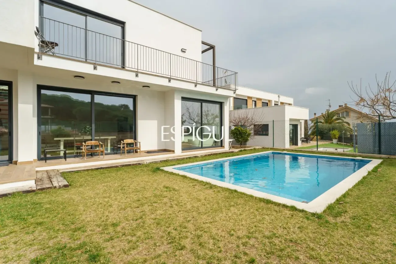 Casa de reciente construcción con piscina, jardín y vistas al mar.