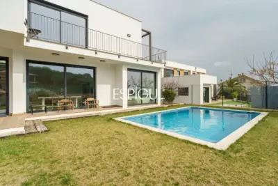 Casa de reciente construcción con piscina, jardín y vistas al mar.