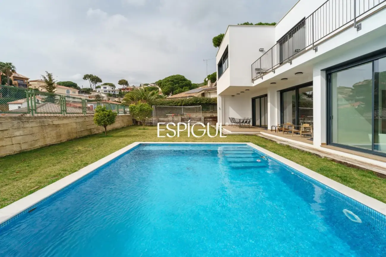 Casa de reciente construcción con piscina, jardín y vistas al mar.