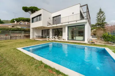 Casa de reciente construcción con piscina, jardín y vistas al mar.