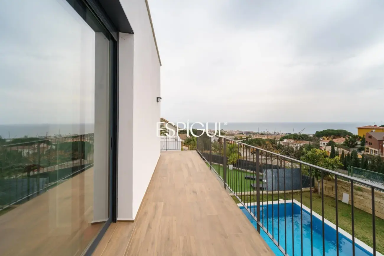 Casa de reciente construcción con piscina, jardín y vistas al mar.