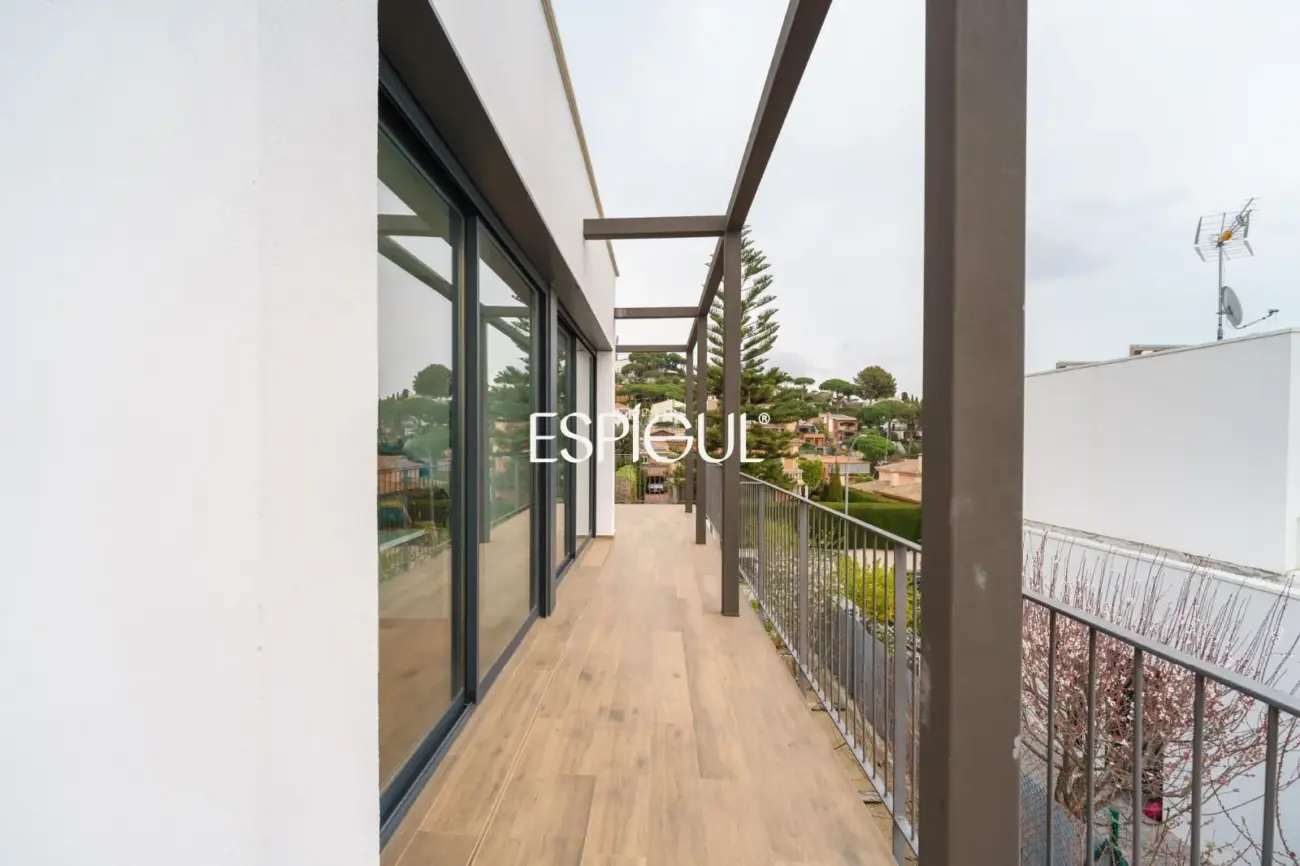 Casa de reciente construcción con piscina, jardín y vistas al mar.