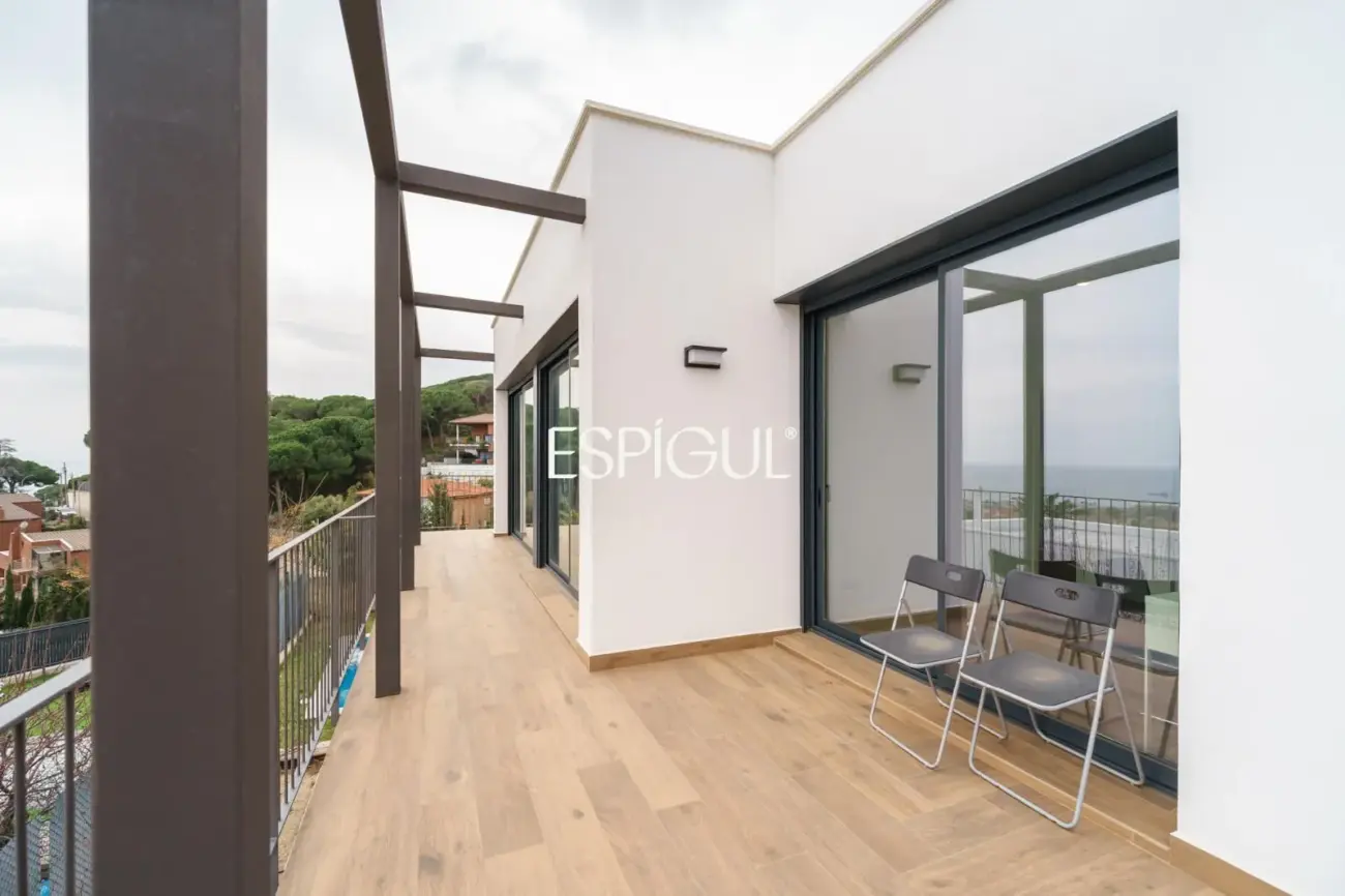 Casa de reciente construcción con piscina, jardín y vistas al mar.